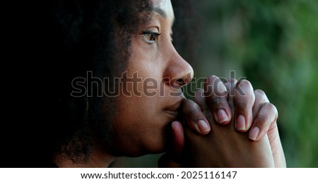 Pensive black woman praying. Thoughtful African person seeking help