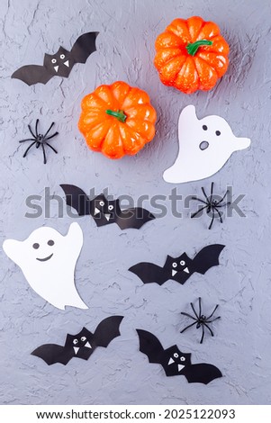 Halloween background with web, spiders, ghosts, bats and pumpkin on a gray, vertical, top view