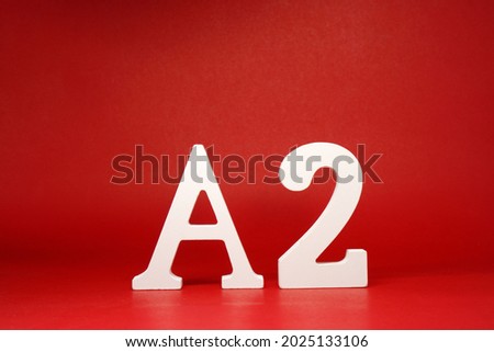 A2 white letter word wooden Isolated Red Background with Copy Space - Advertise object symbol or  Education Concept         
