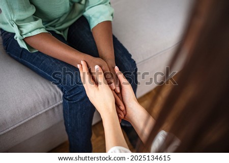 African Peace Symbol. White woman holds hands with a native African girl. A black woman and a white woman hold hands. Peace on earth symbol.  No to Racism!