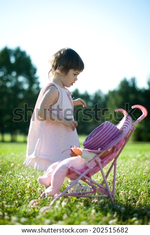 Beautiful little girl walks in the summer park