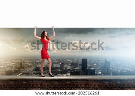 Young woman in red dress holding white blank banner