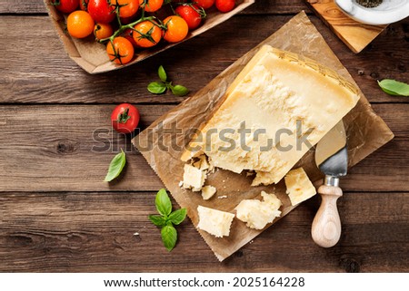 Piece of Parmesan cheese and cheese knife on the wooden table. Top view  Royalty-Free Stock Photo #2025164228