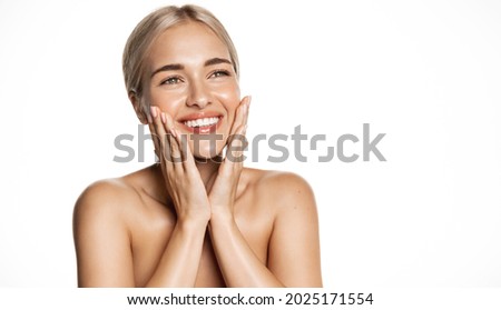 Spa and cosmetology. Young blond woman smiling happy, looking up, holding hands on face, apply moisturizing cream, face lotion or toner, white background Royalty-Free Stock Photo #2025171554