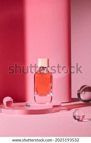Abstract background for branding and minimal presentation. Cosmetic bottle on pink podium, on folding paper pleated geometric background with glass ball. 