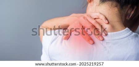woman with her shoulder sprain, muscle painful during overwork. Girl having body problem after wake up. Shoulder ache, Scapular pain, office syndrome and ergonomic concept Royalty-Free Stock Photo #2025219257