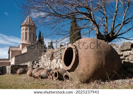 Qvevri, Georgian traditional jug for wine making near the stone wall at monastery Royalty-Free Stock Photo #2025237941