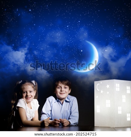 Cute little boy and girl looking at model of house