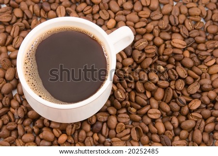 coffee cup with  shaped coffee beans in the background