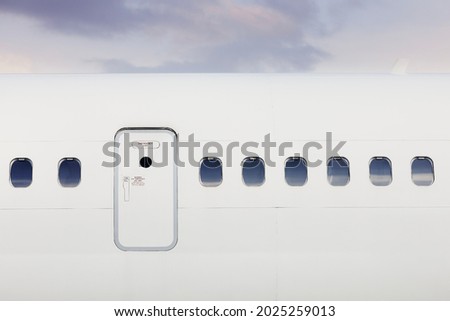Fuselage of airplane with door and windows. Plane against moody sky. Royalty-Free Stock Photo #2025259013