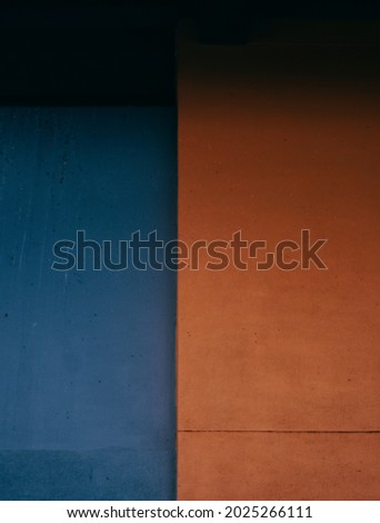 An abstract picture of orange and navy blue walls next to my house.