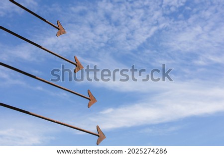 Rusty iron fence with sharp arrows Used for textures and backgrounds. The picture has a color effect. The background is a bright blue sky.