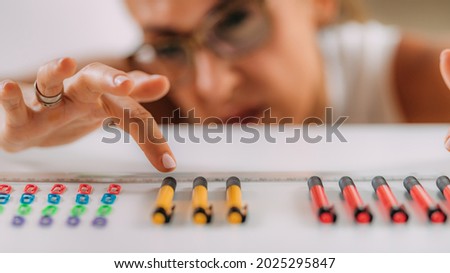 Woman with OCD – Obsessive compulsive disorder concept. Placing paperclips in a straight line. Royalty-Free Stock Photo #2025295847
