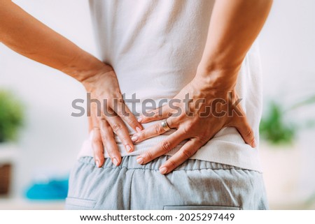 Sciatica or sciatic nerve inflammation, lower back pain. Woman with sciatic nerve pain in her lower back. Royalty-Free Stock Photo #2025297449