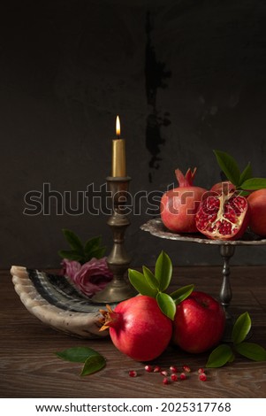 Pomegranates, red apples, shofar (horn) and burning candle on a wooden table, the concept of the Jewish new year - Rosh Hashanah. Royalty-Free Stock Photo #2025317768