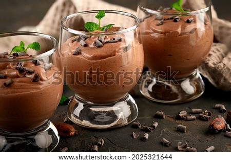 Vegan chocolate mousse with mint, bar of chocolate and cocoa beans on a dark background. Copy space Royalty-Free Stock Photo #2025321644