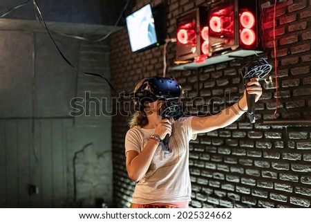 A girl in a VR helmet plays games in a computer club.