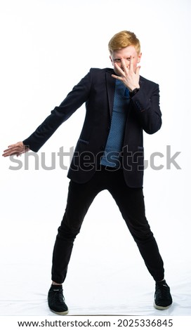 full length portrait of a guy in a jacket and jeans on a white isolated background. teenager dancing, scaring or pretending to be someone