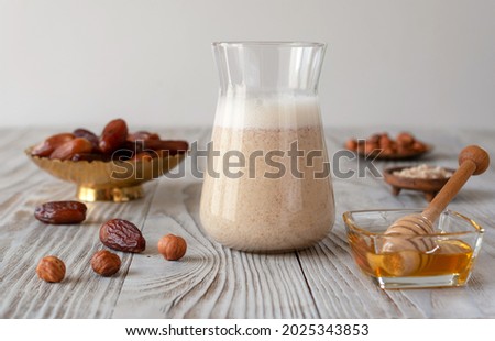 Milkshake made from dates with honey, chopped hazelnuts and chilled oat milk. Proper nutrition concept. Royalty-Free Stock Photo #2025343853