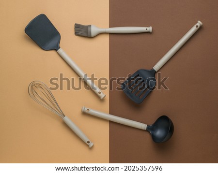 A set of kitchen accessories on a two-color background. Plastic kitchen tools. Flat lay.
