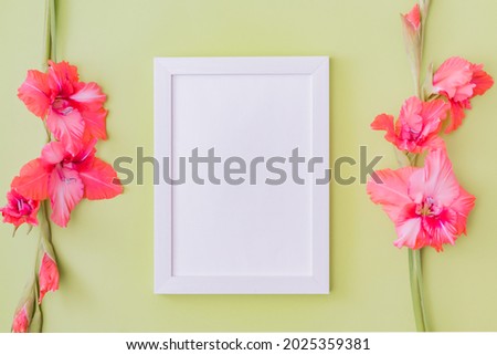 Mockup with a white frame and pink flowers on a green background