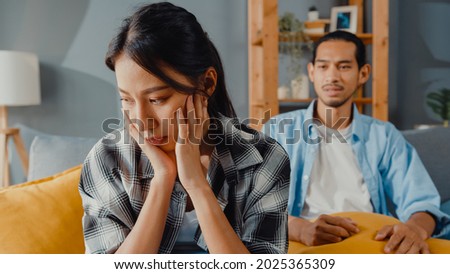 Upset asian couple wife sit on couch listen to furious husband yelling feel unhappy talk negative to her. Couple have fight or disagreement at home, Couple problem, family married toxic relationship. Royalty-Free Stock Photo #2025365309