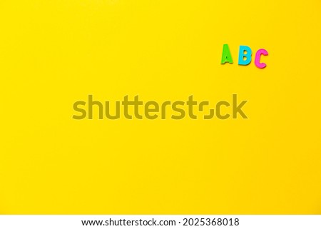 Multicolored letters A, B, C of the alphabet on a yellow background. Learning foreign language for beginners. Primary school education, grammar lesson. Banner on educational theme with free text space