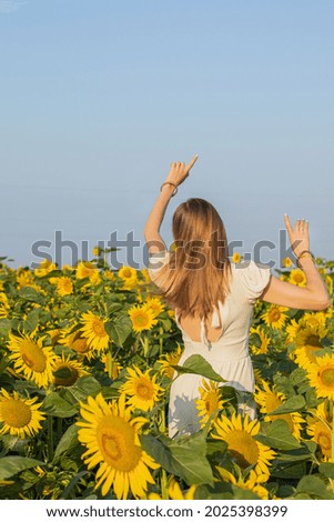 Sunny beautiful picture of young girl with arms raised up in air. Enjoy moment.