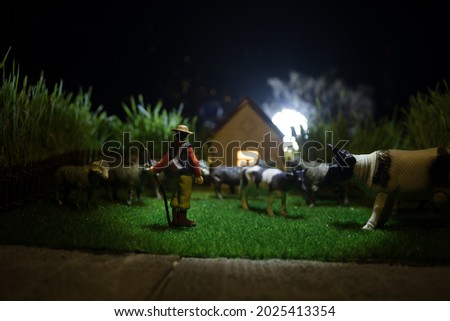 Herd of cows in the farm. Farm (village) life concept. Decorative toy figures at night. Selective focus