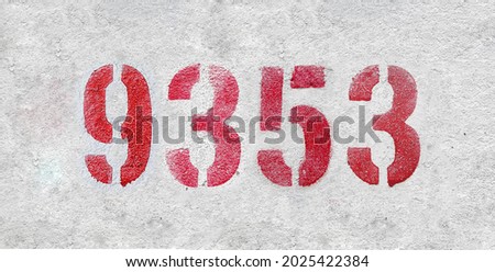Red Number 9353 on the white wall. Spray paint. Number nine thousand three hundred fifty three.