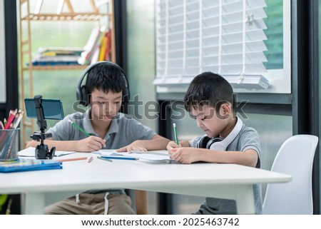 Child boy is using communicates on the Internet at home. homeschooling, distant learning, Asian little boy taking a class online and happy for Homeschool Quarantine.