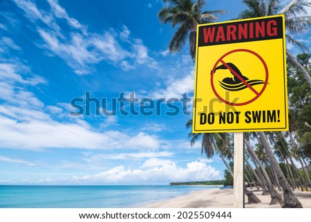 A no swimming sign at a beach. A warning sign to the public. Tropical beach setting.