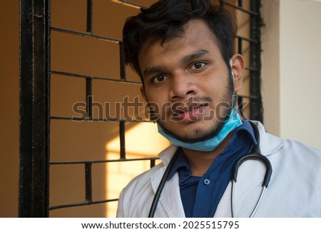 male doctor is wearing lab coat and looking at camera