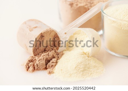 Sports nutrition, fitness diet and food concept - whey and soy protein shake   powder  on blue background Royalty-Free Stock Photo #2025520442