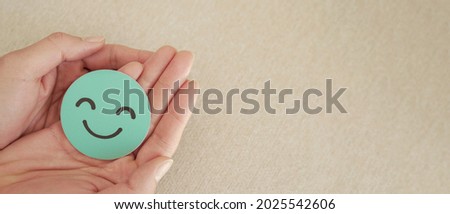 Hands holding green happy smile face paper cut, good feedback rating and positive customer review,experience, satisfaction survey,mental health assessment,child feeling good,world mental health day Royalty-Free Stock Photo #2025542606