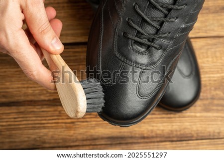 cleaning, polishing, restoration black leather boots with brush and footwear care product, shoe polish Royalty-Free Stock Photo #2025551297