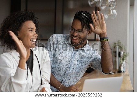 Happy African couple reading on laptop good news gesturing giving high five, feel excited by online bid win, celebrate lottery victory. Achieved new opportunity, loan approval, ecommerce sale concept Royalty-Free Stock Photo #2025559232