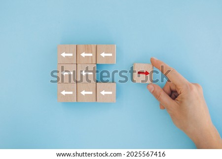 Female hand placing or pulling Red block with different direction of arrow on white background. Business Growth, Improvement, strategy, Successful, different and Unique Concepts