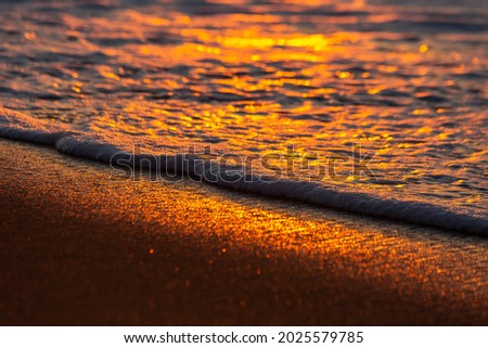 golden morning sunrise with wave crashing on the beach