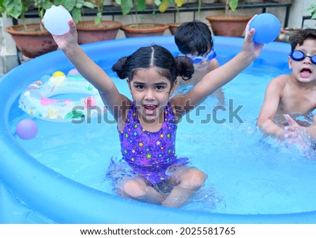 Children having fun in home pool on terrace