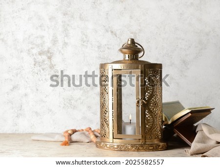 Muslim lantern with Quran and tasbih on grunge background