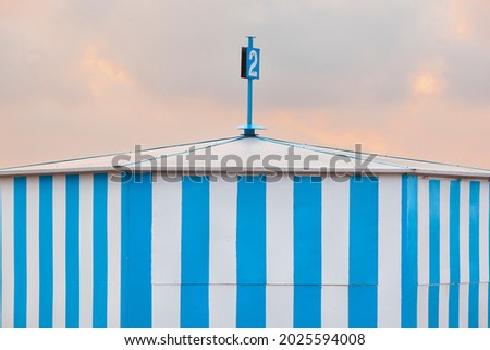 Blue striped beach cabin at sunset. Summer time. Tourism