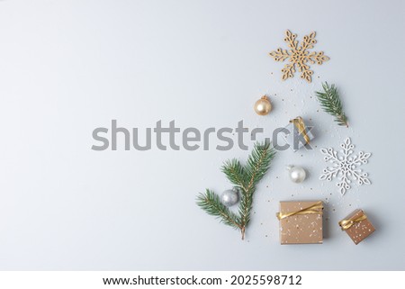 Christmas tree shape made with gifts in craft and Christmas decorations on grey background. Flat lay, copy space