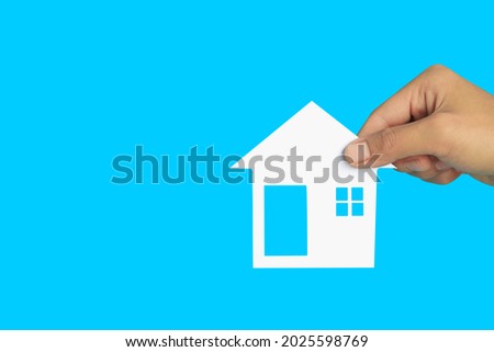 The house in human hands  on blue background, Real estate concept, Mortgage property home concept, Copy space.