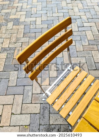 Wooden chairs on a cobblestone sideway in front of a restaurant. High angle view.