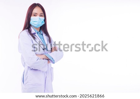 Friendly young woman doctor wear uniform coat, protection medical face mask with stethoscope standing arms crossed over isolated white background. Health care occupation concept.