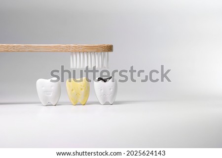 Wooden toothbrush on Healthy, yellow and cavity teeth, Maintain oral hygiene thoroughly and regularly by brushing your teeth with fluoride toothpaste every time.                                        Royalty-Free Stock Photo #2025624143