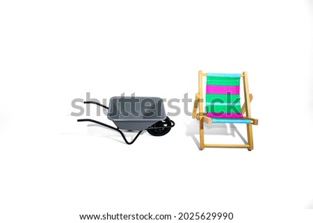 Sun lounger and garden wheelbarrow as a concept of a country vacation isolated close-up on a white background.
