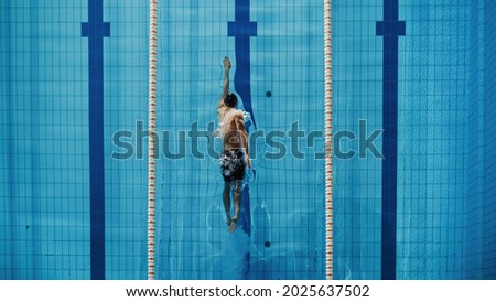 Aerial Top View Male Swimmer Swimming in Swimming Pool. Professional Athlete Training for the Championship, using Front Crawl, Freestyle Technique. Top Down View. Royalty-Free Stock Photo #2025637502