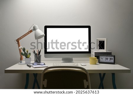 Front view with whitoffice desk that have lamp, stationary set, cactus, notepapers, eyeglasses, computer, keyboard, mouse, cup of coffee, books, table clock, picture frame decorated.